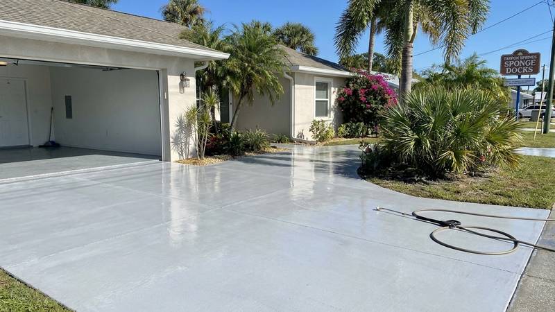 Example of driveway pressure washing in Clearwater, FL — after soft washing. Concrete - rust stains + tire marks. Even-pressure surface cleaner.