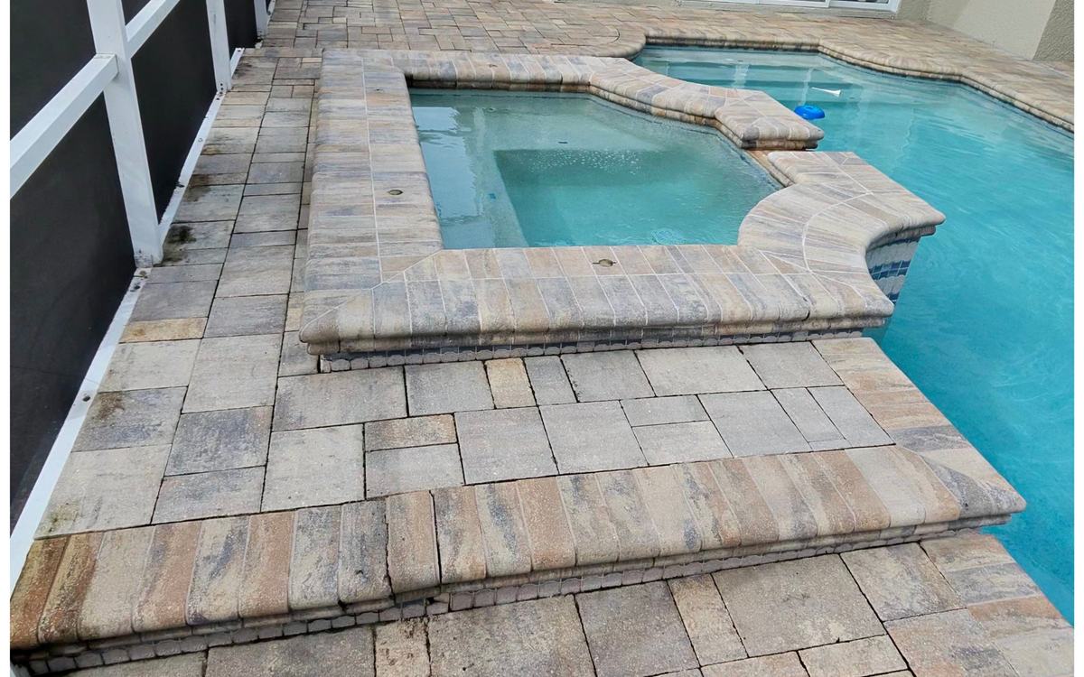Faded, grimy paver pool deck and spa surround before Sandbar cleaning — real job photo