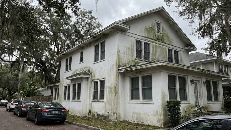 Example of house washing in Dunedin, FL — before soft washing. Stucco + soffit refresh. 2-story colonial - soffit, fascia, screens included.